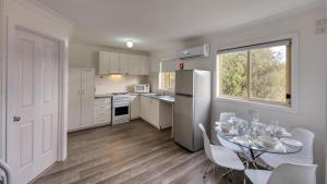 a kitchen with white cabinets and white appliances at Junee Motor Inn in Junee