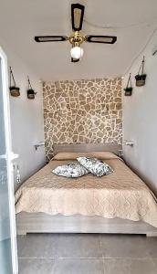 a bed in a room with a stone wall at Trullo Oasi Veronica in Ostuni