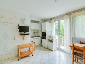 コトレにあるStudio Cauterets, 1 pièce, 4 personnes - FR-1-401-48の白いキャビネットと大きな窓付きのキッチン