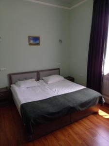 Schlafzimmer mit einem Bett mit weißer Bettwäsche und einem Fenster in der Unterkunft Apart Hotel Sayat-Nova in Wanadsor