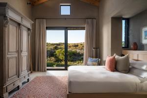 a bedroom with a large bed and a large window at Romansbaai Collection in Gansbaai