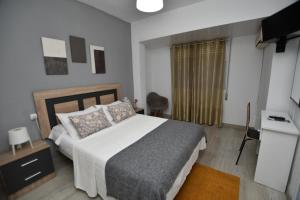 a bedroom with a bed and a desk and a television at Hostal HB Torrevieja in Torrevieja