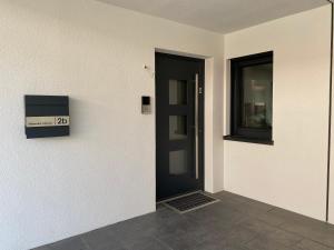 a black door in a white room with a window at Mittendrin Ortenau -keine Monteurwohnung- in Kehl am Rhein