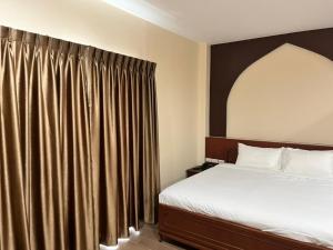 A bed or beds in a room at Anwari Hotel