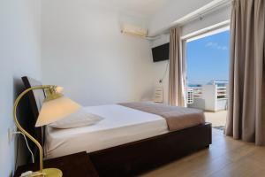 a bedroom with a bed and a window with a view at Archontiki City Hotel in Chania