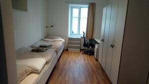 una piccola camera da letto con due letti e una finestra di Bajta na obzidju a Maribor