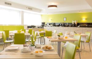 a restaurant with tables and chairs with food on them at Hotel Cristina in Naples