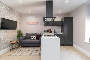 a living room with a couch and a kitchen at Chelmsford Lofts - High-spec luxury apartments in Jesmond