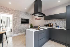 a kitchen with black and white cabinets and a sink at Chelmsford Lofts - High-spec luxury apartments in Jesmond