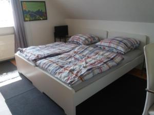 a bedroom with a bed with a quilt and pillows at Ruhiges Zimmer direkt an den Leineauen in Hemmingen
