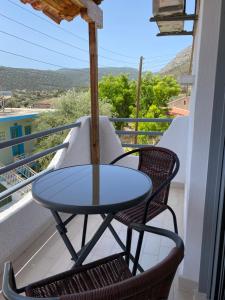 a table and chairs on a balcony with a view at Georgina in Agia Marina Aegina