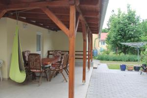 un patio con mesa, sillas y sombrilla en Family Vendégház, en Balatonszárszó