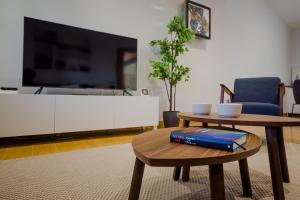 a living room with a table and a tv at La Casa del Mar in Chiclana de la Frontera