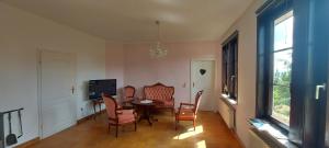 a dining room with a table and chairs and a television at Zum Alten Pfarrhaus in Damscheid