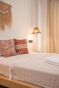 a bedroom with a bed with pillows and a lamp at LUPA ALAÇATI in Çeşme