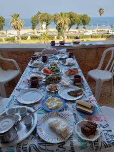 un tavolo pieno di cibo con vista sulla spiaggia di First Sea Line Apartment, Acre - amazing coastal view in heart of Akko a ‘Akko