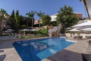 a large swimming pool with chairs and umbrellas at Hotel Costa Málaga - Adults Recommended - by Pierre & Vacances in Torremolinos
