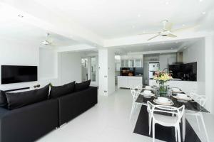 ein Wohnzimmer mit einer schwarzen Couch und einem Tisch in der Unterkunft Villa Yindee managed by Villa For You in Koh Samui 