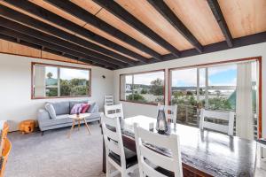 een woonkamer met een tafel en een bank bij Couches, Bar Table & Kawau View in Snells Beach