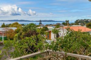 een uitzicht op de stad vanuit een huis bij Couches, Bar Table & Kawau View in Snells Beach