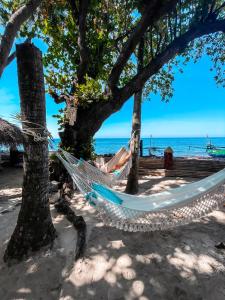 uma rede na praia debaixo das árvores em Cili Emas Oceanside Resort em Tejakula