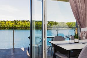 a room with a table and a view of the water at Apartamenty Mazurskie Klimaty (Cud Natury) in Tomaszkowo +76 photos