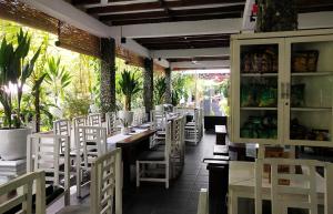 New The Heritage Resort & Restaurant Bukit Lawang في Bandartelu: غرفة طعام مع كراسي وطاولات بيضاء وسيدكس سيدكس سيدكس