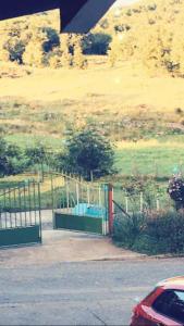 a gate in a parking lot next to a field at Chambre familiale à la ferme in Montesquieu-Avantès