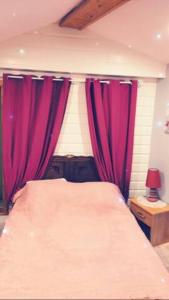 een slaapkamer met rode gordijnen en een bed met een lamp bij Chambre familiale à la ferme in Montesquieu-Avantès
