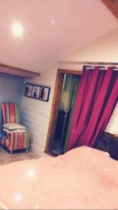 een slaapkamer met een bed en een raam met paarse gordijnen bij Chambre familiale à la ferme in Montesquieu-Avantès