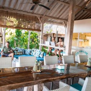 un grupo de personas sentadas en un patio con una mesa en Cili Emas Oceanside Resort, en Tejakula