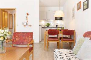 een woonkamer met een tafel en stoelen en een keuken bij Ferienwohnung Ostseerauschen im Kaiserhof 4 in Kellenhusen
