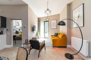 a living room with a yellow couch and a table at Chelmsford Lofts - High-spec luxury apartments in Jesmond