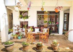 a patio with a table and chairs and potted plants at Evergreen House - 150Metre Walk To City Mall Nyali in Mombasa