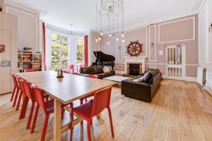 ein Wohnzimmer mit einem Tisch, Stühlen und einem Sofa in der Unterkunft Lee Abbey London in London