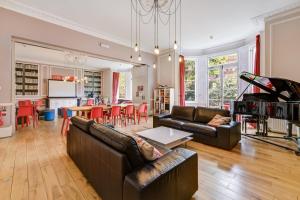 a living room with two leather couches and a kitchen at Lee Abbey London in London