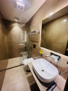 La salle de bains est pourvue d'un lavabo, de toilettes et d'une douche. dans l'établissement Sugar Stars Inn, à Varanasi