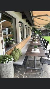 szereg stołów i krzeseł na patio w obiekcie Restaurant Gästehaus Wiesenheim w mieście Uderns