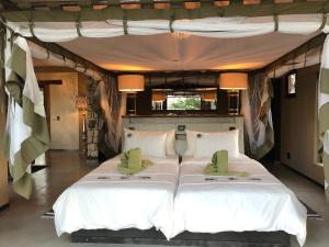 a bedroom with a large bed in a tent at Etosha Oberland Lodge in Okaukuejo