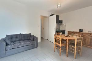 a living room with a couch and a table and a kitchen at Confortable appartement pour 4 personnes proche de la plage in Valras-Plage