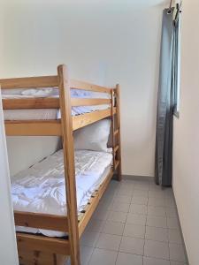 a couple of bunk beds in a room at Confortable appartement pour 4 personnes proche de la plage in Valras-Plage