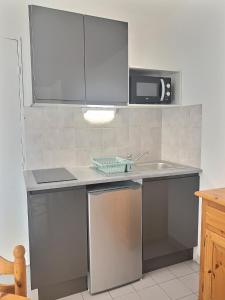 a kitchen with a sink and a microwave at Confortable appartement pour 4 personnes proche de la plage in Valras-Plage