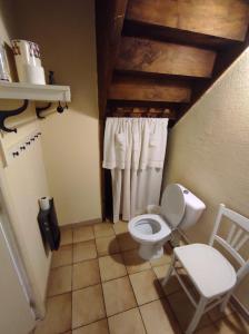 Baño pequeño con aseo y silla en gite le vieux perrin, en Andelaroche 22 fotos más