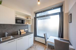 a kitchen with a sink and a table and a window at City Center Lofts in Vienna