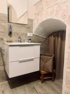 baño con lavabo y silla en BOSA HOME B&B, en Ceglie Messapica