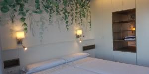 a bedroom with a bed with two lights on the wall at pleno centro nuevo parking in León