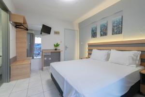 a bedroom with a large white bed and a staircase at Agnandi in Neos Marmaras
