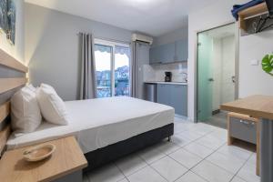 a bedroom with a large bed and a kitchen at Agnandi in Neos Marmaras