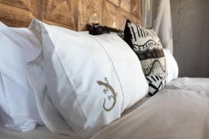 a pile of pillows sitting on a bed at Desert Homestead Lodge in Sesriem