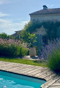 um jardim com piscina e uma casa com flores em M de Maumey em Sainte-Radegonde